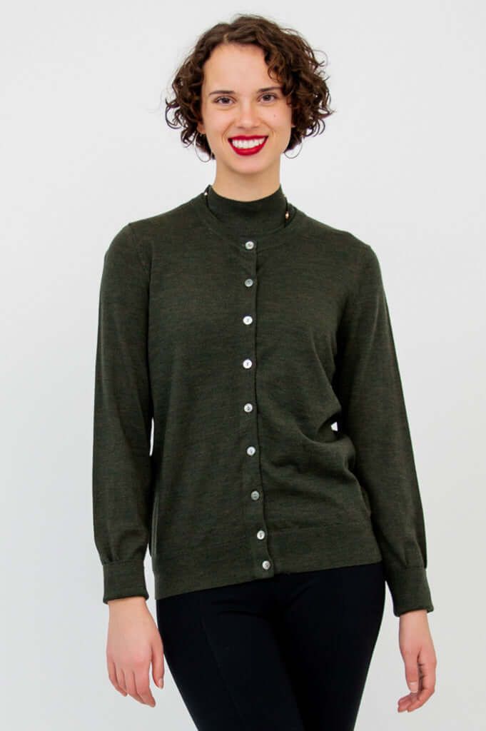 Model wearing the Rita Merino Wool Sweater layered under a dark green cardigan