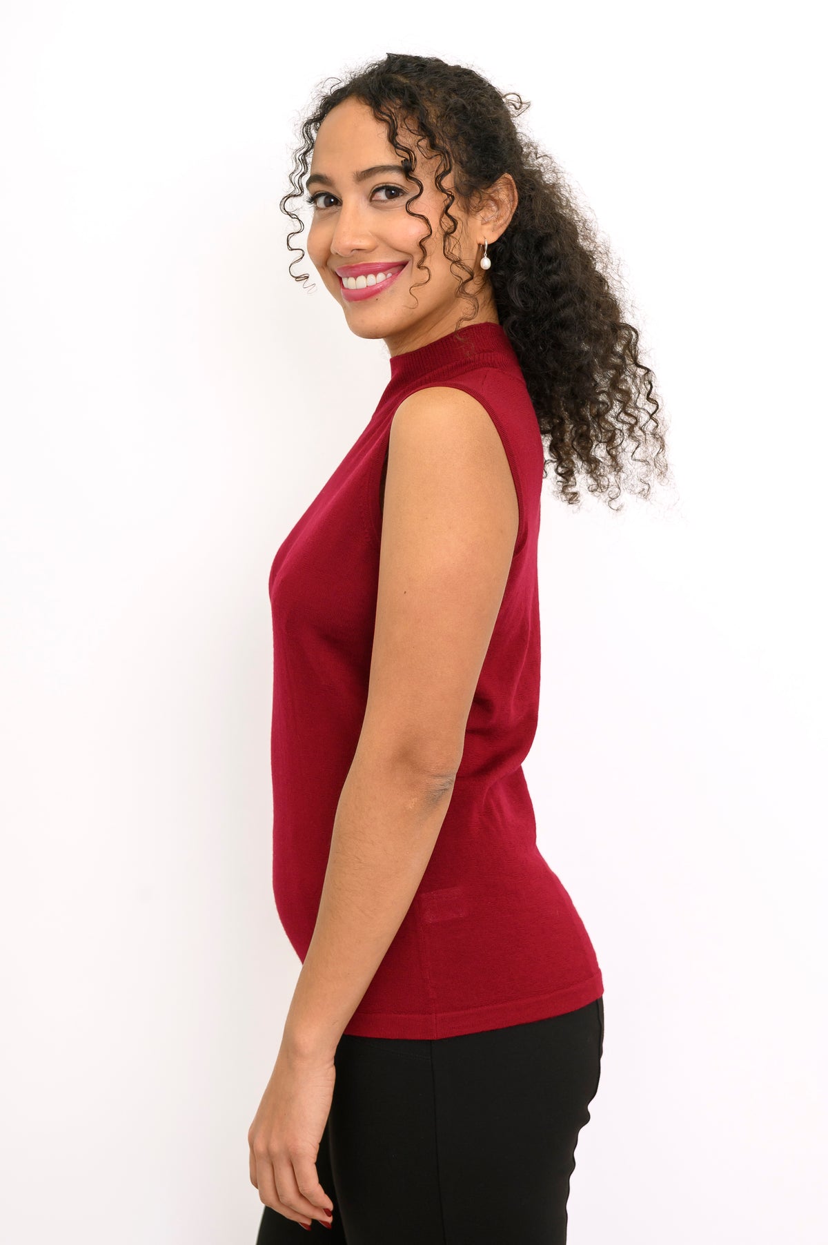 Profile shot of a dark red sleeveless knit top showing slim fitting silhouette and side seam detail.