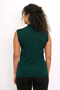 Back view of a woman wearing a hip length deep forest green sleeveless merino wool top in studio.