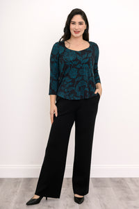 Front view of a dark teal patterned A-line top and black pants, showcasing a relaxed and fluid silhouette.