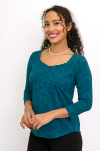 Angled shot of a teal patterned bamboo top with three-quarter sleeves, showing a comfortable, fluid drape.