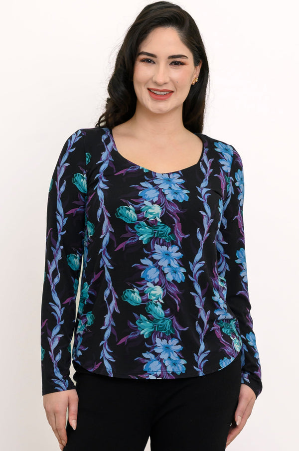 Front view of a female model wearing a blue and black patterned long-sleeve top with black pants against a white background