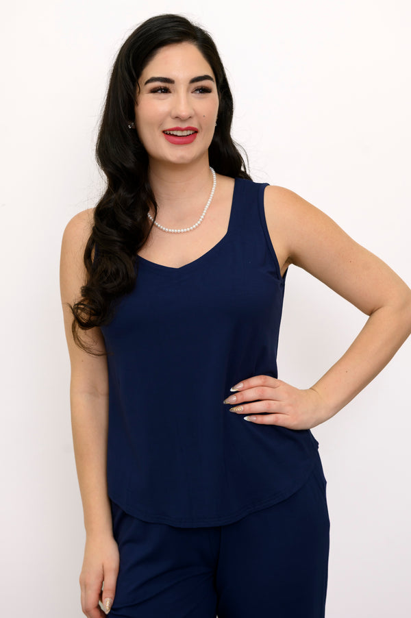 Woman wearing a navy blue sleeveless top and matching pants on a white background, front view