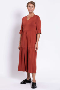Model in rust midi dress with keyhole neckline and relaxed fit
