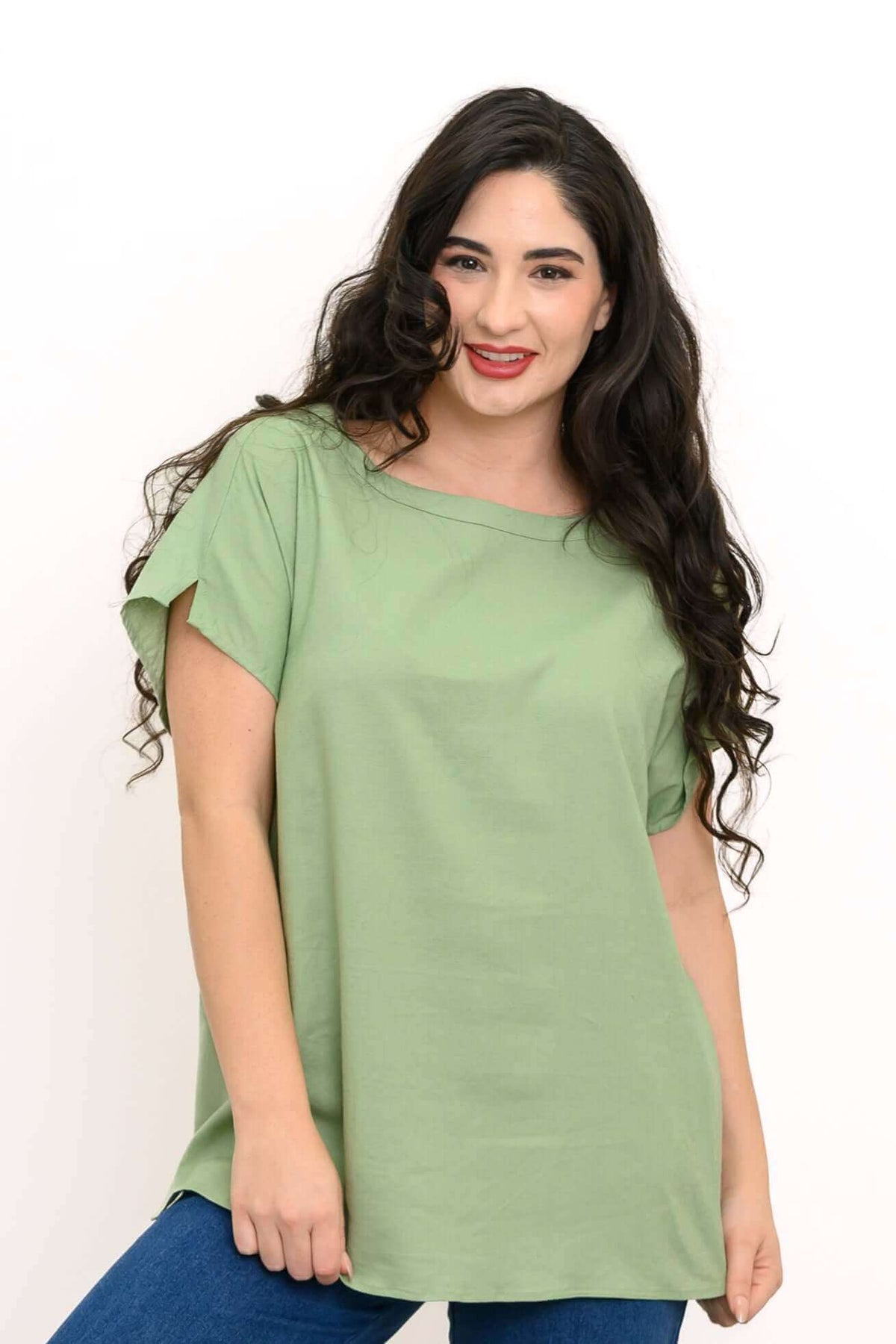 Woman wearing a sage green linen blend tee with dolman sleeves, posing against a white background