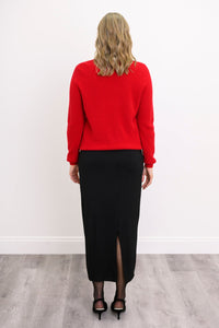 Three quarter angled shot of a woman modeling a red wool blend cardigan with red pearl button detail.