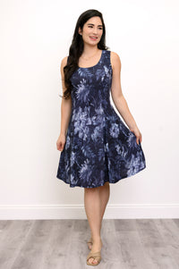 Woman wearing a navy blue floral patterned shirt and black pants against a white background, front view