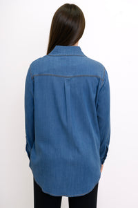 Back close-up view of woman wearing denim shirt with back pleat, collar, and rounded hem