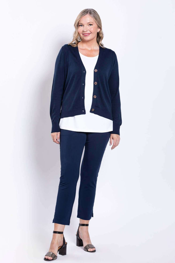 Model wearing navy slim-fit pants and navy cardigan, standing front facing arms relaxed