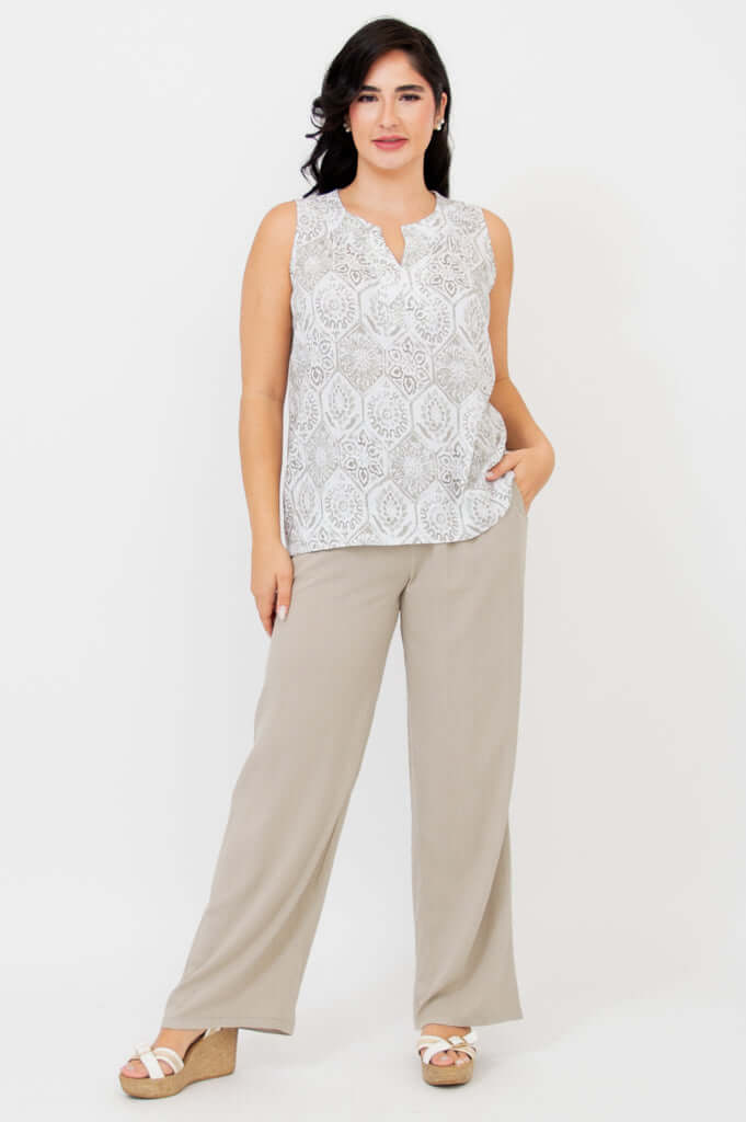 Full-length view of woman in sleeveless patterned tank and beige wide-leg pants