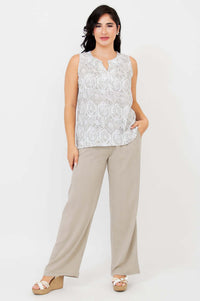 Full-length view of woman in sleeveless patterned tank and beige wide-leg pants