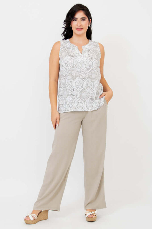 Full-length view of woman in sleeveless patterned tank and beige wide-leg pants