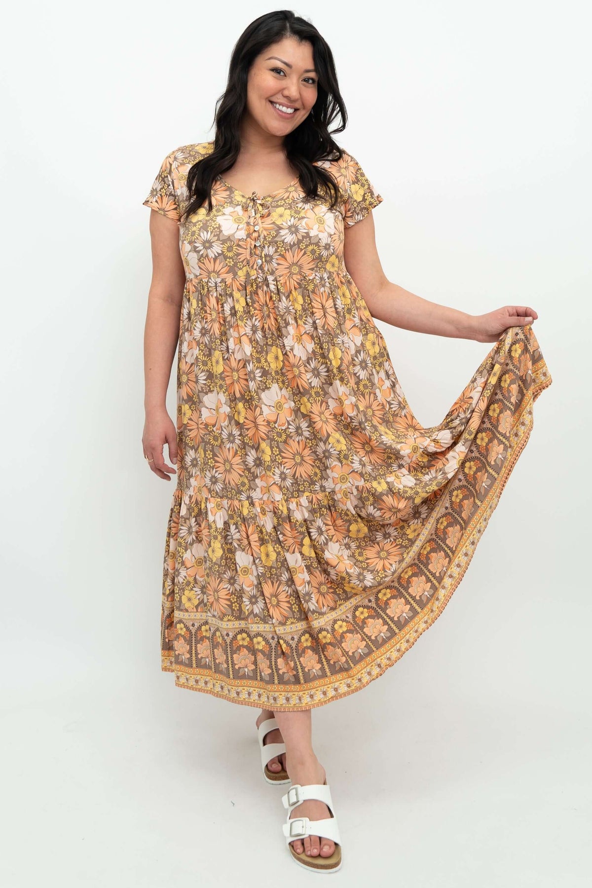 Woman holding out the tiered skirt of the floral Sharpie dress