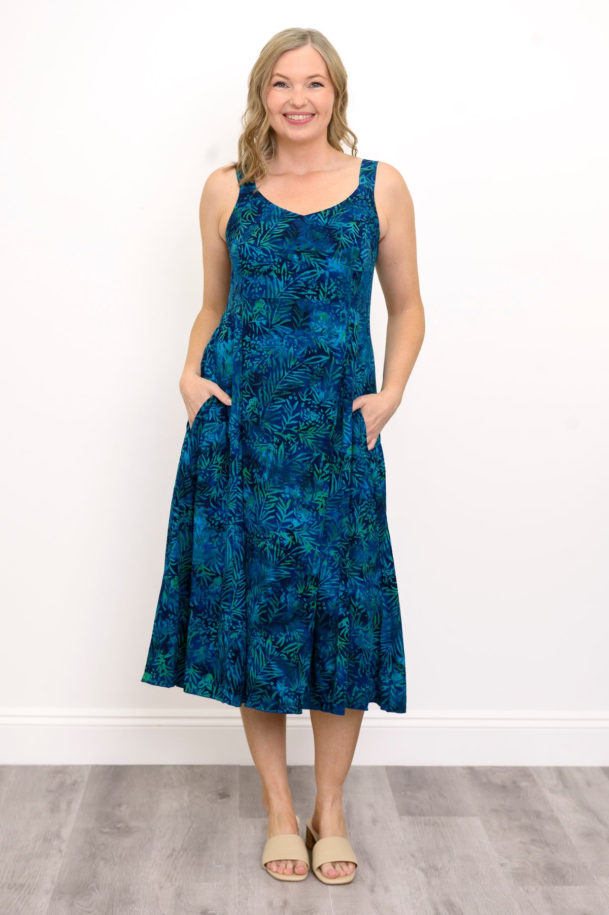 Woman wearing a blue patterned dress against a white background, front view