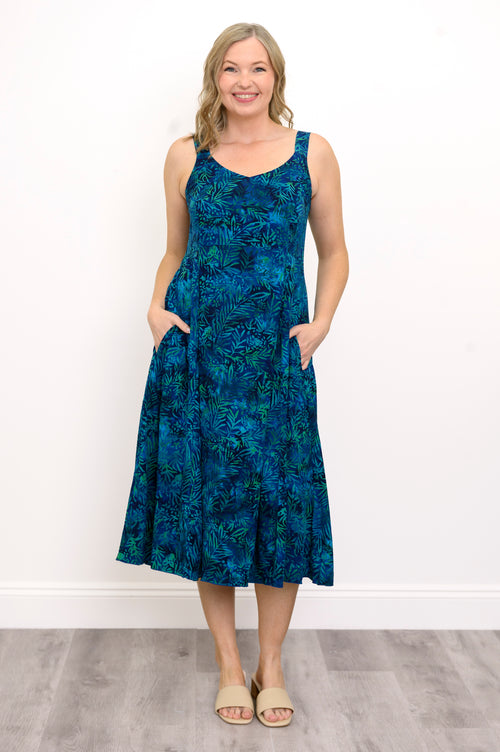 Woman wearing a blue patterned dress against a white background, front view