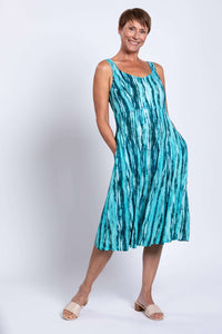 Woman posing with hand in pocket, wearing teal streak bamboo linen dress