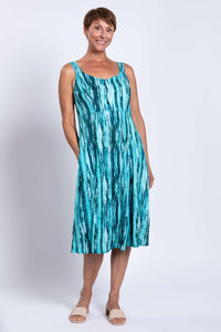 Woman wearing a teal streak bamboo linen sleeveless dress, standing and smiling