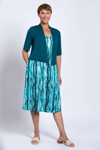 Woman wearing teal streak dress paired with a teal shrug, front view