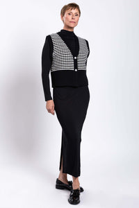 Side angled view of model in wool-cashmere vest with black and white stripes