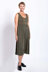 Side view of woman in an olive green empire waist midi dress
