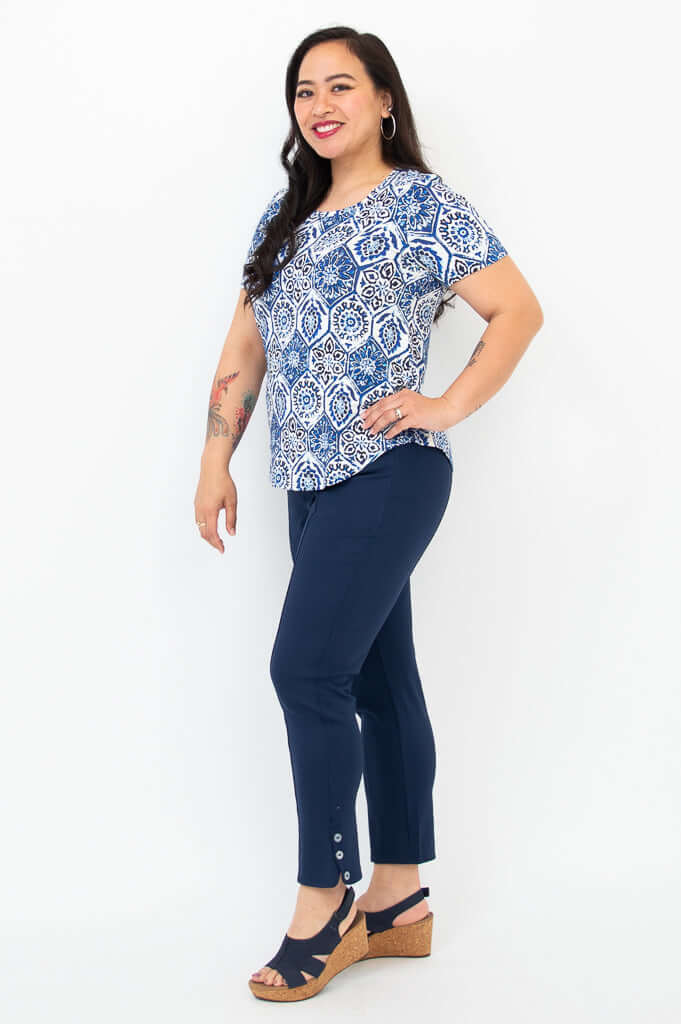 Side view of blue mosaic Tessa Tee paired with navy pants and wedge sandals