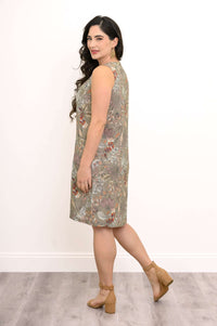 Side view of woman in olive floral sleeveless dress, showing split neckline