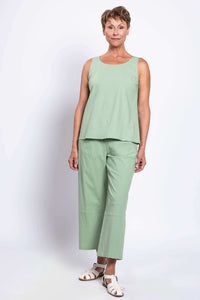 Woman modeling sage green cropped linen pants and sleeveless top, angled to the side