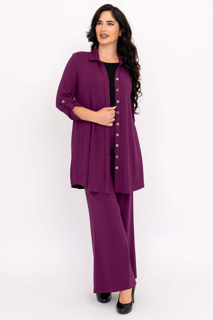 Plus model in plum tunic blouse with matching pants, looking left