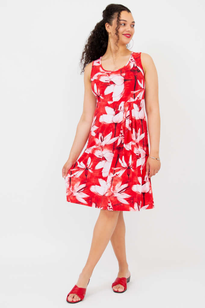 Side view of model in a red and white floral pleated dress