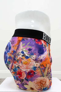 Side perspective of men's bamboo floral boxer briefs showing bright flowers and logo waistband