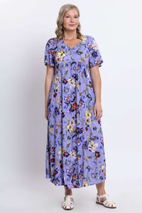 Woman turned slightly to the side wearing a purple floral maxi dress with short flutter sleeves