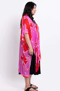 Side profile of a woman in a pink and red floral kimono wrap and black dress