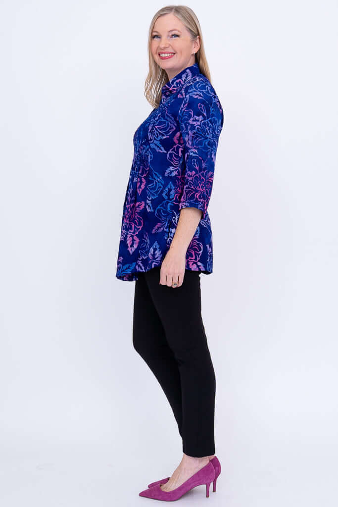 Side view of woman in blue and purple floral tunic and black pants