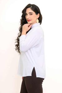 Side profile of a woman showcasing the white mock neck top's side slit