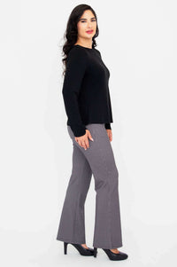 Side profile of woman in black Mona boat neck long sleeve top and check pants