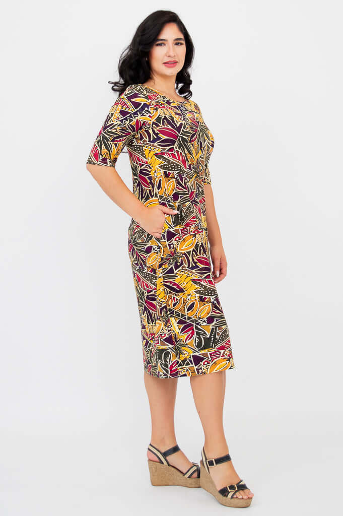 Side view of woman in Olivia dress in Tropikal pattern with one hand in pocket
