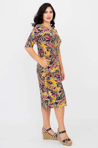 Side view of woman in Olivia dress in Tropikal pattern with one hand in pocket