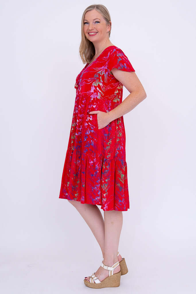 Side view of woman in red flutter sleeve dress showing fit and flare