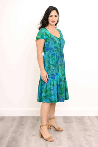 Side view of woman in green and blue tiered short sleeve midi dress