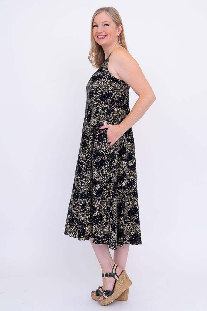 Side view of the model in the Shauna sleeveless midi dress with hands in pockets