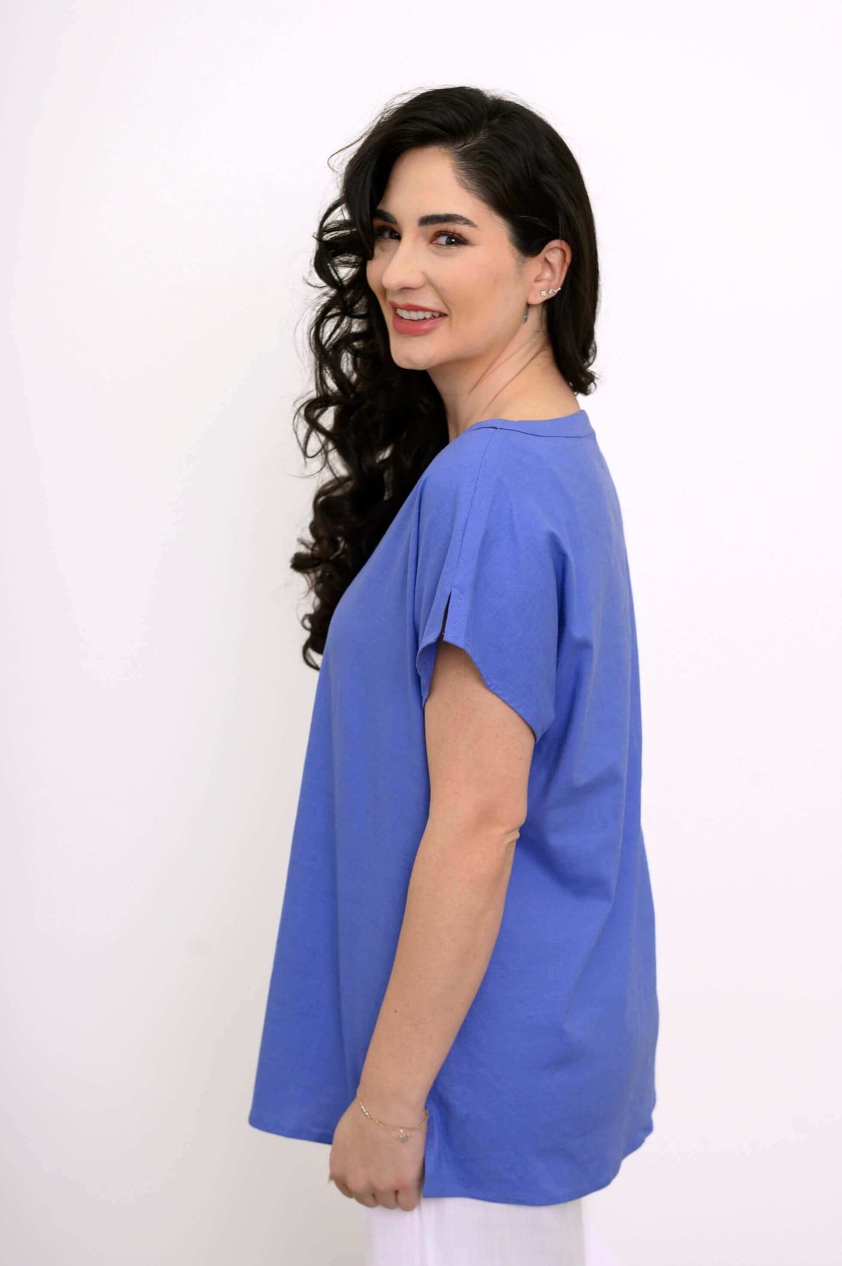 Woman in a blue boatneck tee with cap dolman sleeves, side profile