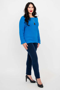 Side angle of a model in a blue raglan sleeve sweater and navy pants