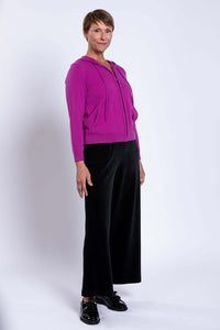 Side view of woman modeling magenta wool cashmere hoodie and black pants