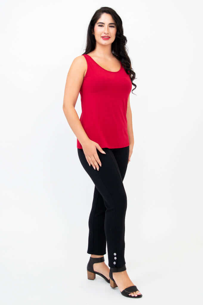 Side angle of woman in ruby red bamboo tank top and black pants with button detail