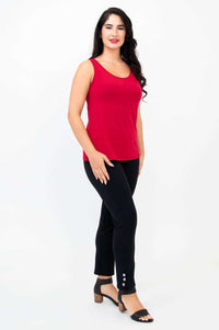 Side angle of woman in ruby red bamboo tank top and black pants with button detail