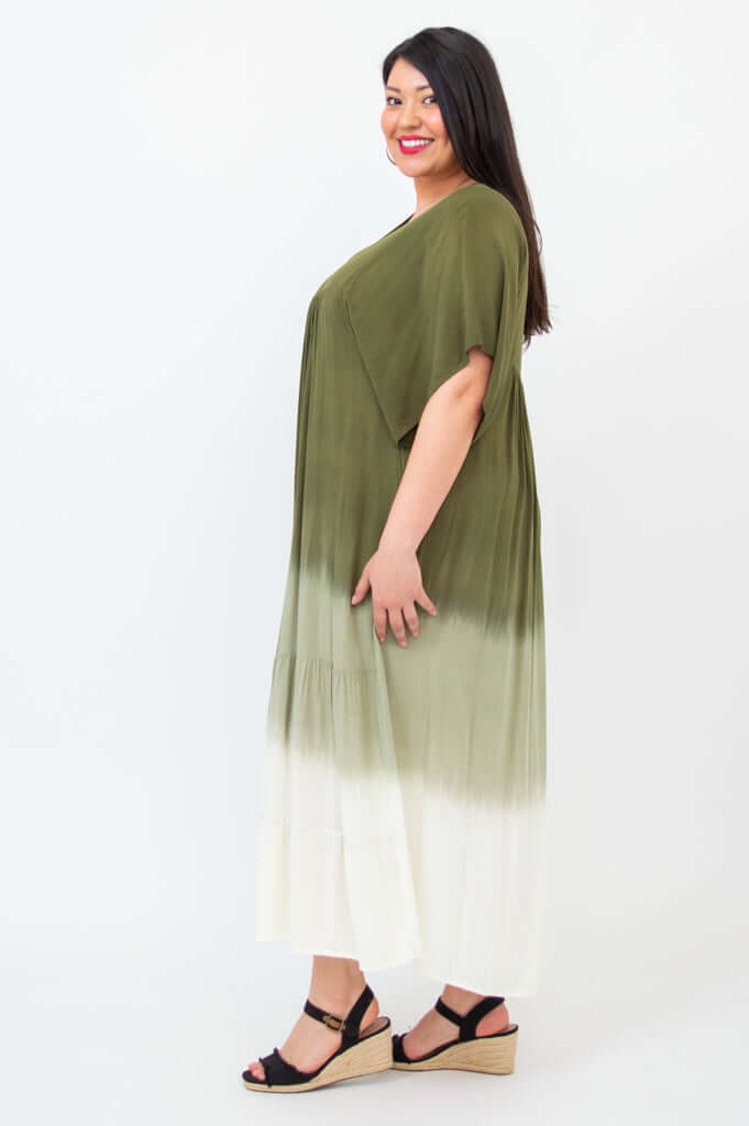 Side profile of a woman in an olive ombre tiered maxi dress with V-neckline
