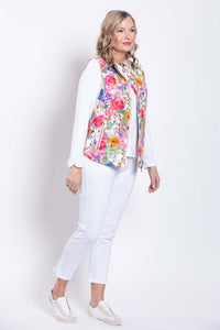 Side view of woman in a pink floral print vest and white pants