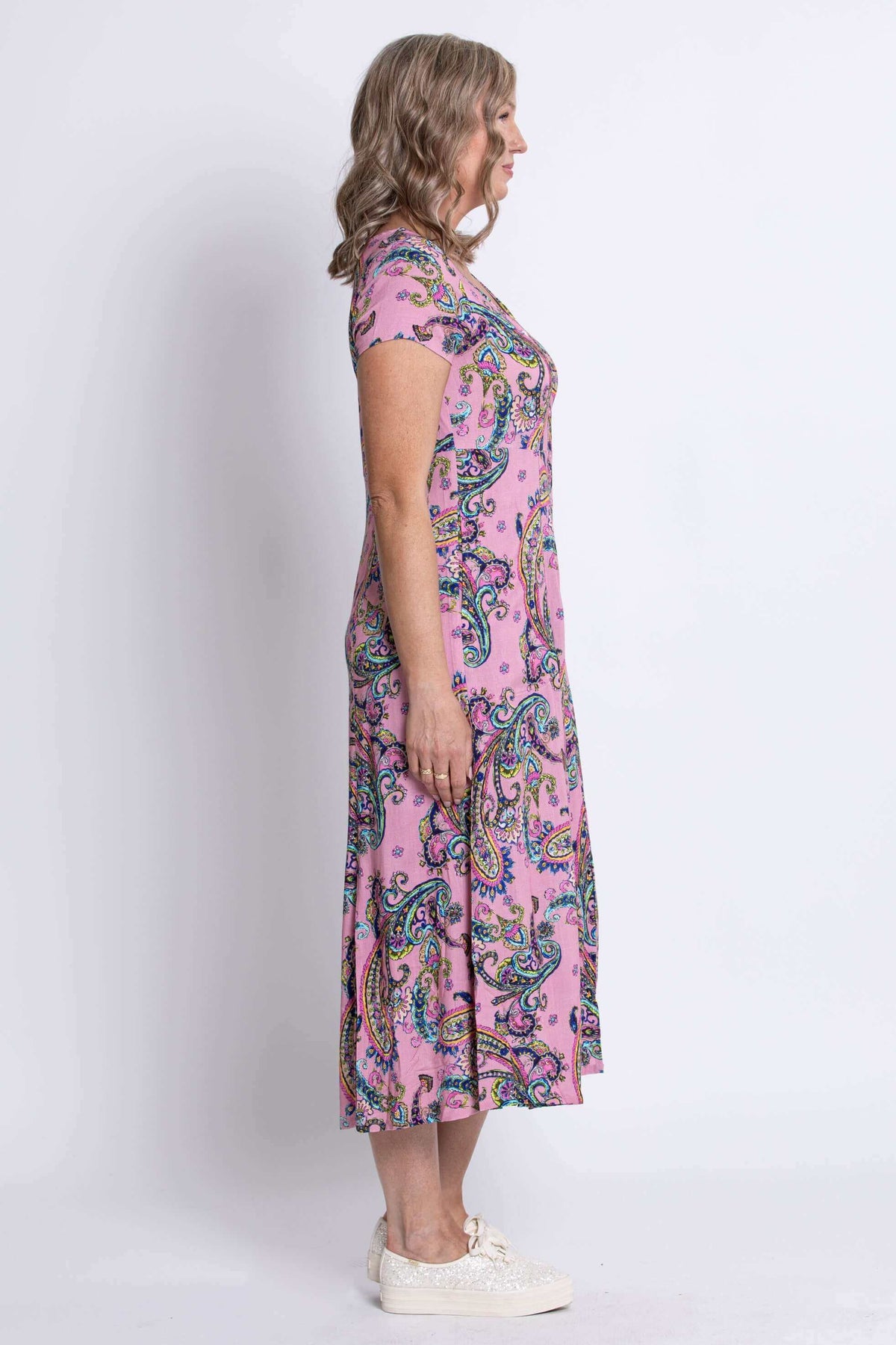 Side profile of a woman modeling a pink paisley print midi dress