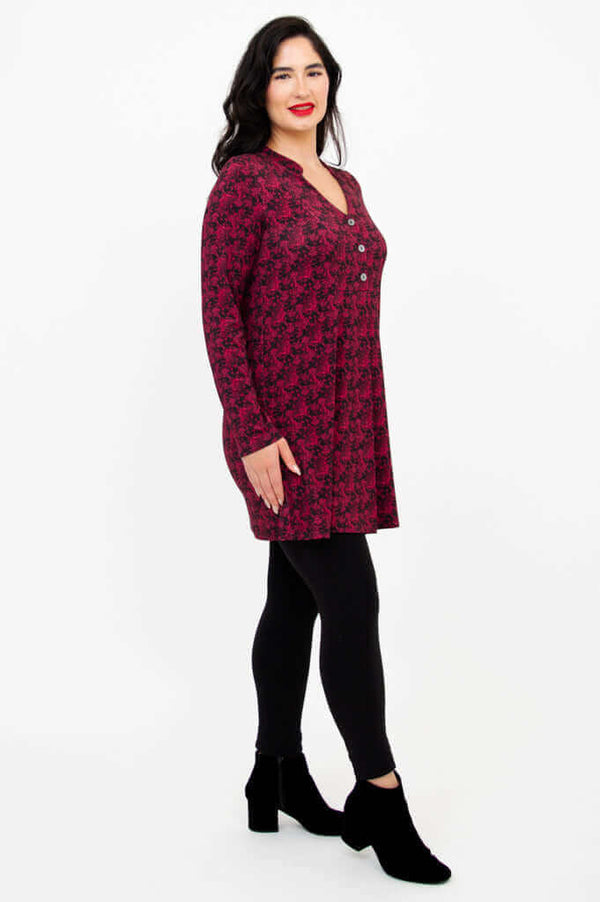 Side profile of model in the Edwina tunic showing three-button placket and long sleeves