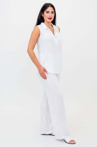 Side view of woman in white quarter-zip tank and wide-leg pants